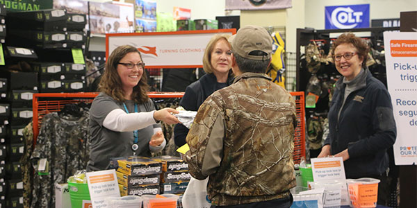 A participant at a recent firearm-safety event attended by Seattle Mayor Jenny Durkan, center, receives information on safe firearm storage and a free safety device from Lara Sim, Seattle Children’s Hospital, on the left and Tracy Gooding, Harborview Medical Center. The public events were put on by Seattle Children’s in 10 Washington communities between 2015 and 2018.Kelsie Cleboski/Harborview Injury Prevention & Research Center