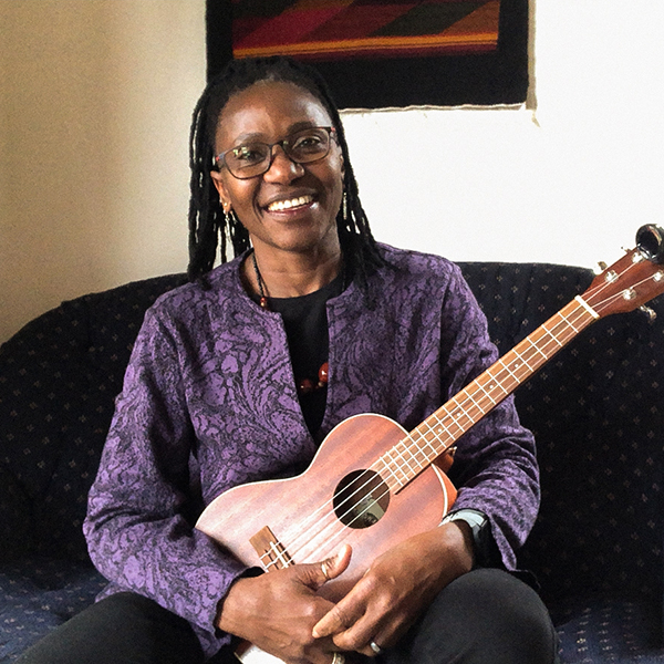 Ahoua Koné smiling and holding an acoustic instrument