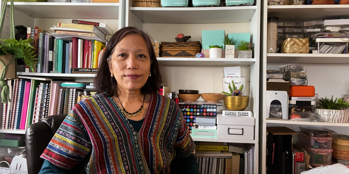 Victoria Gardner in front of a bookshelf with plants