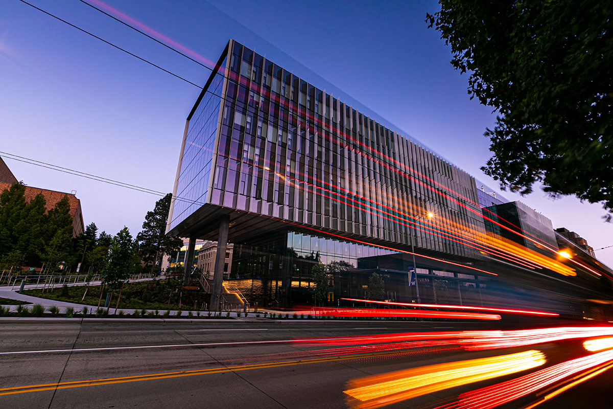 Long exposure photo of light trails from cars in front of the Hans Rosling Center for Population Health