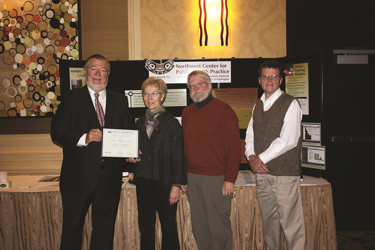 A group photo with former directors of the center holding up a document