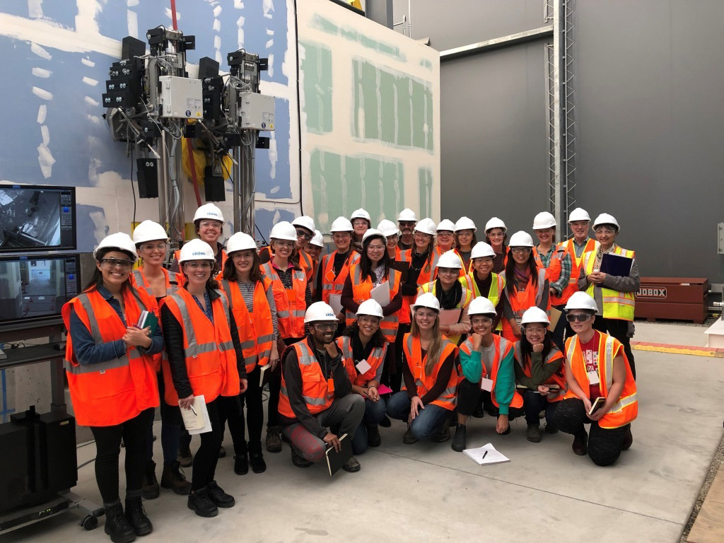 Group photo of COPHP with graduates and faculty members wearing hard hats and orange vests