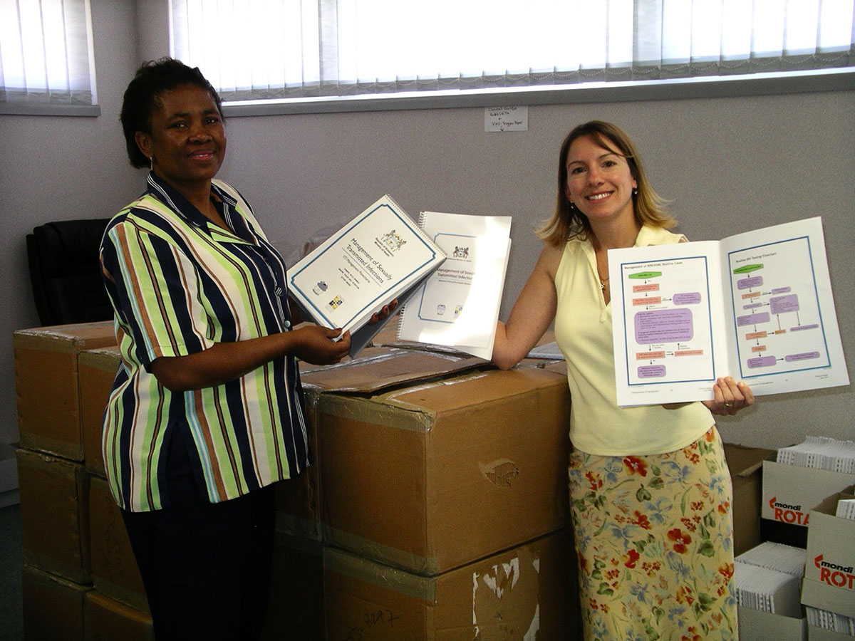 I-TECH partners holding up a guide for an STI course in Botswana from 2006