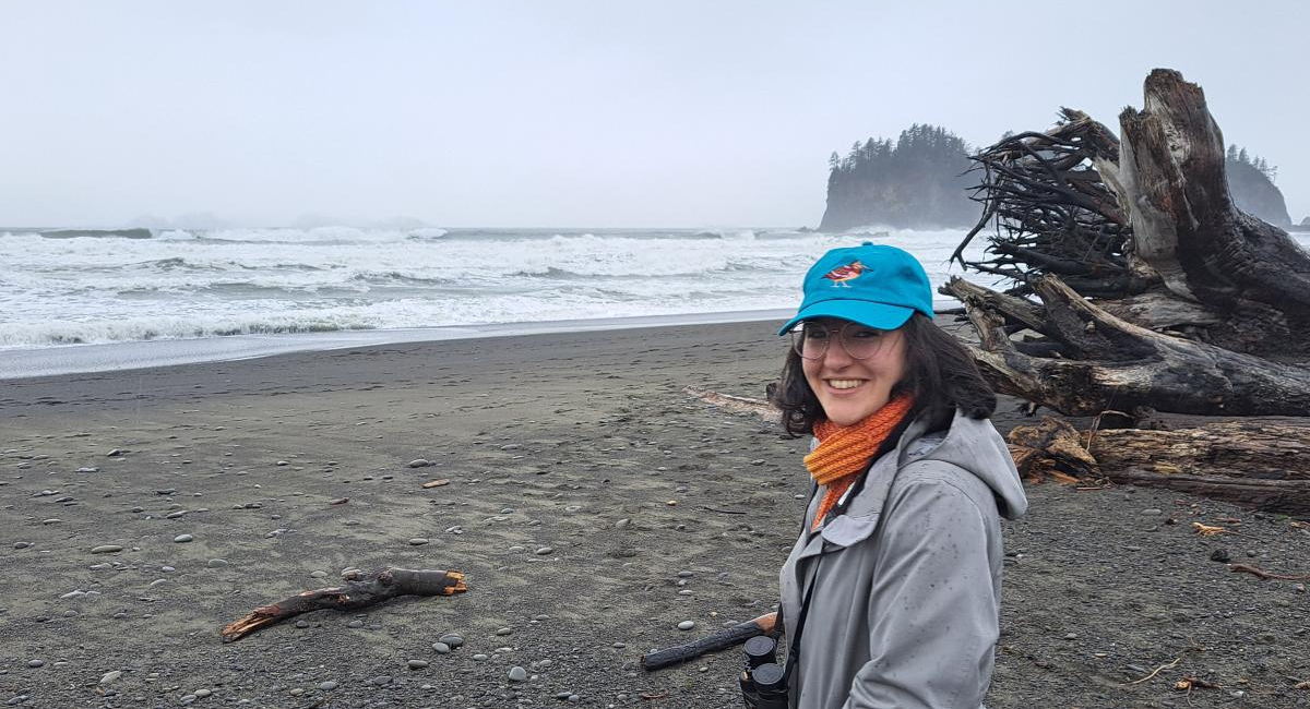 Cecilia Martindale stands on a cloudy ocean beach