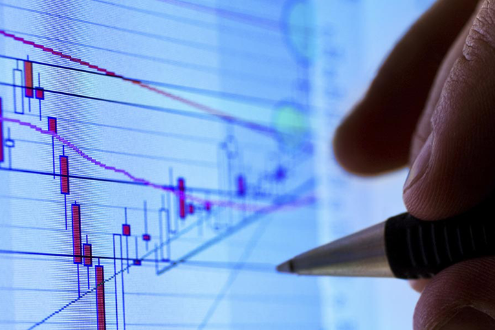 A pen marking a candles graph