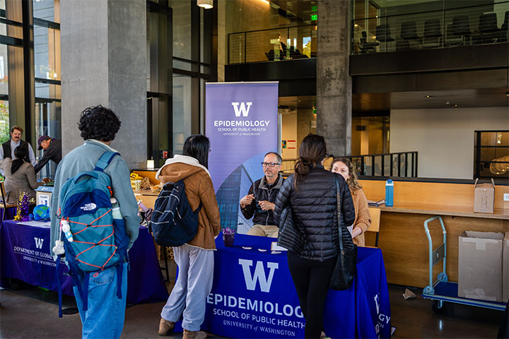 Students checking in at a table with a UW Epidemiology banner