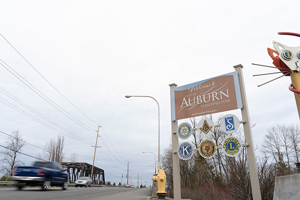 Sign for the city of Auburn in front of a train track