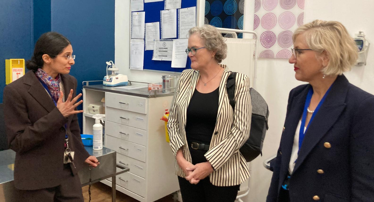 Jeanne stands in a medical room with two other people