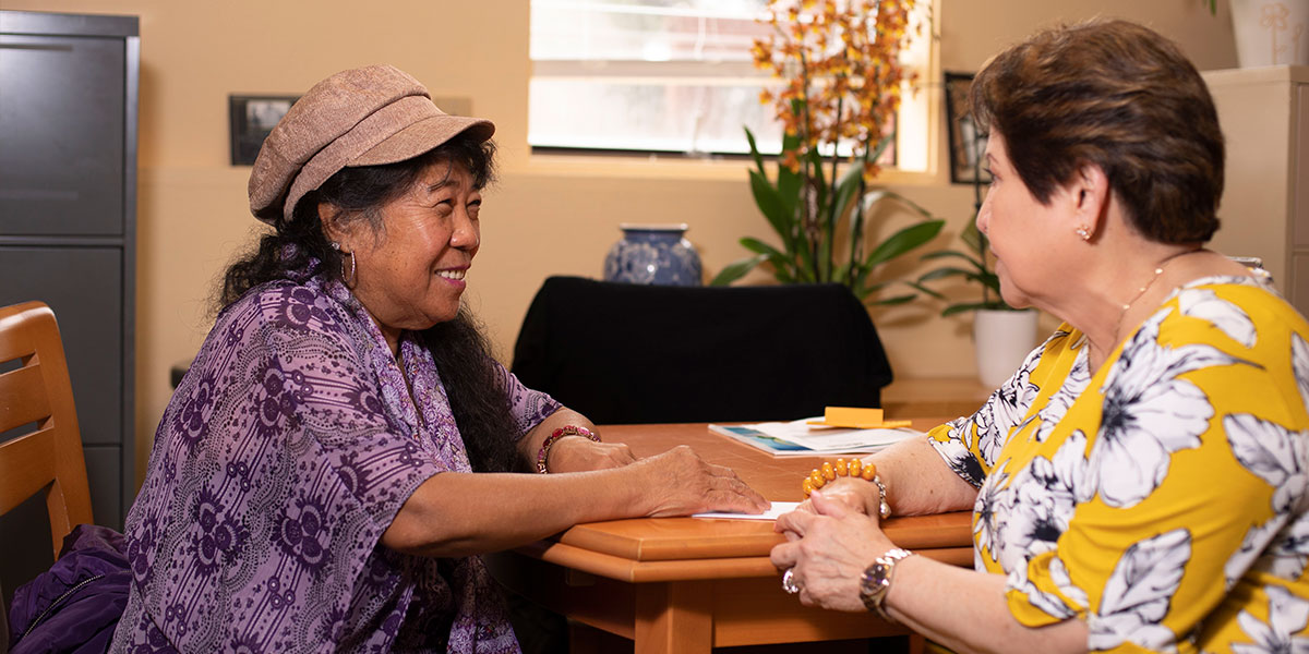 Vilma Carver (left) knows all the members and staff of the International Drop-In Center, including Marivic Rigor, a data manager and counselor with the center. Carver often visits the center to see friends, have lunch and help as needed.