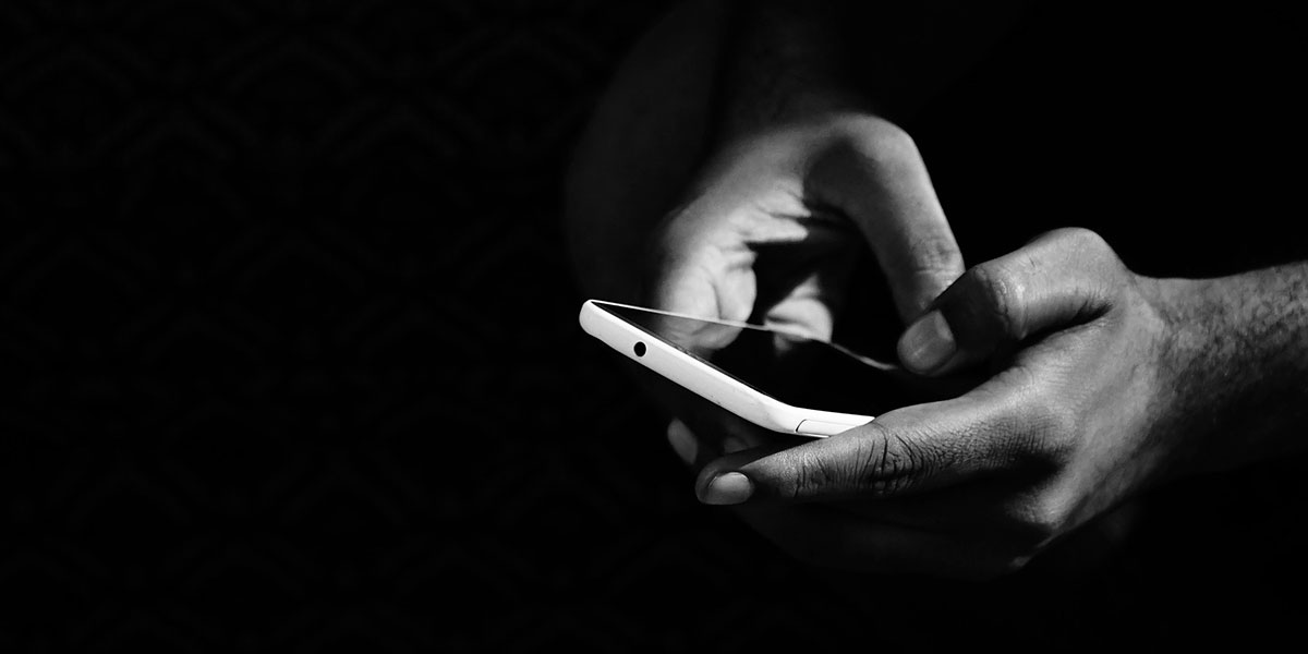 black and white photo of hands holding a cellphone