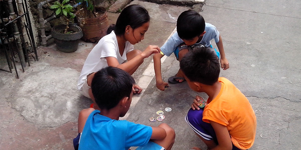 Filipino children playing pogs on the street [(CC by-SA 3.0) Jewel457]