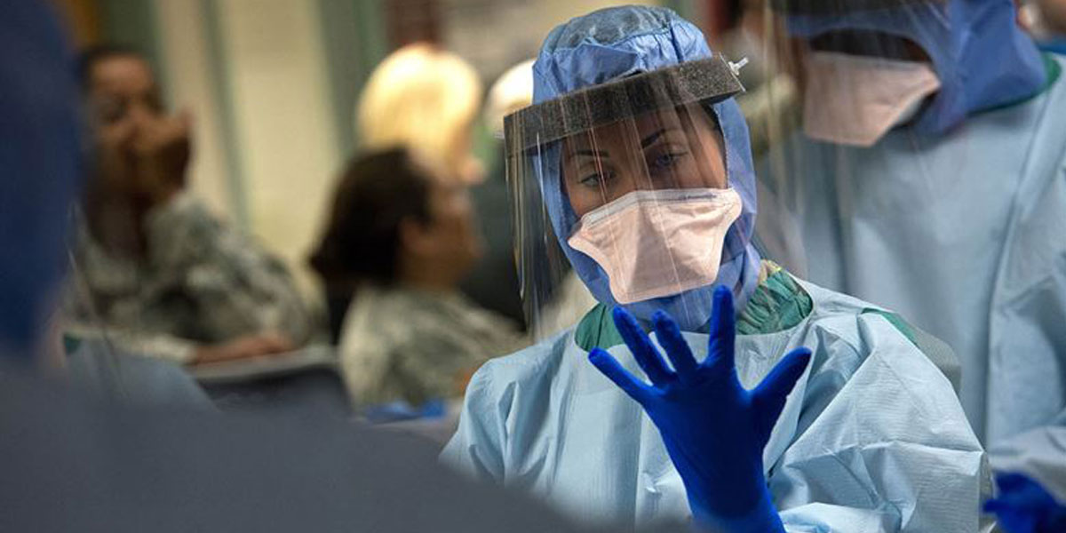 Member of an Ebola medical support team dons protective gloves during infection prevention and control training at the San Antonio Military Medical Center. (U.S. Air Force photo/Master Sgt. Jeffrey Allen)