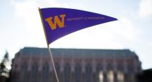 University of Washington purple and gold flag waves in front of Suzzallo Library