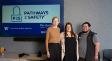 Three people stand in front of sign reading Pathways 2 Safety